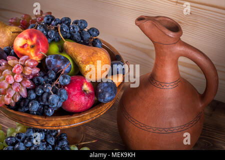 Fruits d'automne de la vie toujours avec le Georgian verseuse sur fond de table en bois rustique. Banque D'Images