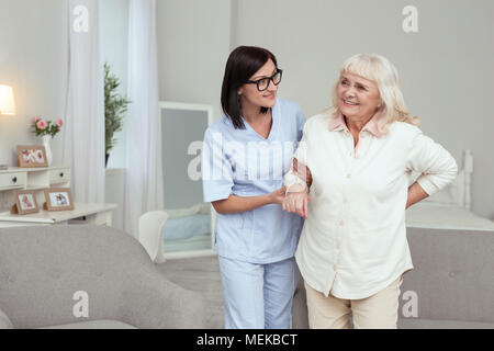 Joyeux nurse assisting woman aîné Banque D'Images