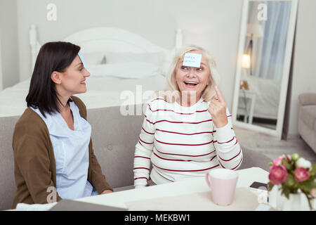 Aîné heureux jeu de femme et des soignants Banque D'Images