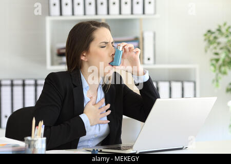 Exécutif Asmathic ayant une crise d'asthme l'inhalation avec un inhalateur at office Banque D'Images