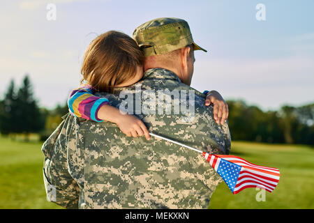 Petite fille se serrant ses fathger soldat américain. Banque D'Images