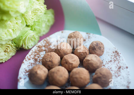 Bonbons à la main sur une plaque blanche Banque D'Images