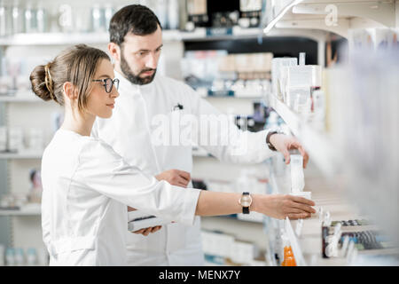 Les pharmaciens travaillant dans le magasin de la pharmacie Banque D'Images