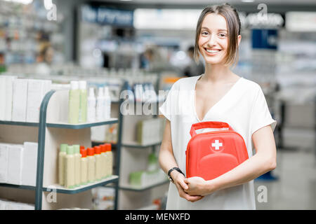 Femme avec trousse de premiers soins dans la pharmacie Banque D'Images