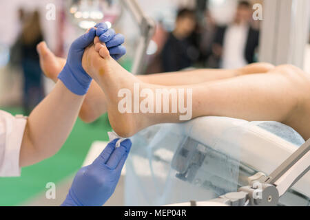 Jolie Médecin examinant un patient âgé's foot. Banque D'Images