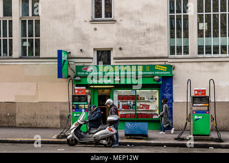 Un opérateur de pompe à essence ravitaille un scooter à une station service sur le Boulevard de Clichy, Pigalle, Montmartre, Paris Banque D'Images