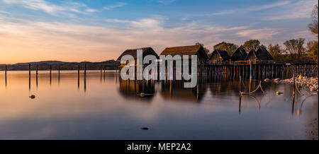 Colourfull coucher du soleil au lac de logements de la pierre et de l'Âge de Bronze à Unteruhldingen sur le lac de Constance, Baden-Wurttemberg. Allemagne Banque D'Images