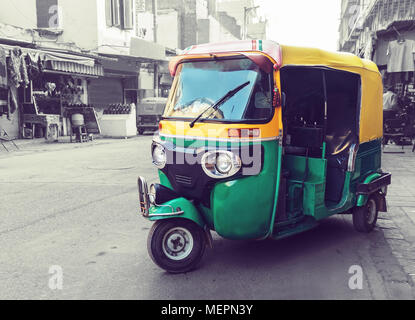 Jaune Vert traditionnel tuk tuk taxi sur la rue. Transports publics indiens dans les rues de New Delhi. Banque D'Images