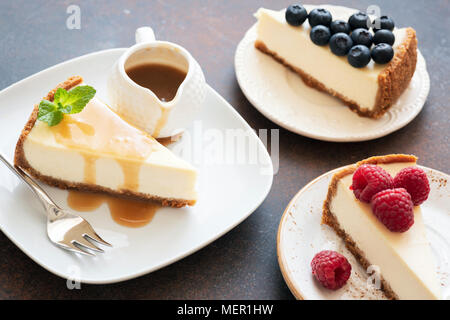 Assortiment de crème glacée avec différentes garnitures. Cheesecake aux framboises, gâteau au fromage avec sauce au caramel gâteau au fromage et aux bleuets Banque D'Images