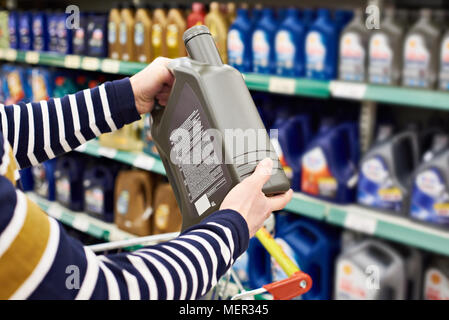 Acheteur mâle choisit l'huile pour moteur de voiture en magasin Banque D'Images