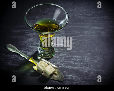 Photo d'un verre d'absinthe avec cuillère et de cubes de sucre. Banque D'Images