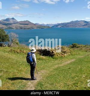 Touriste à Leitir Fura sur l'île de Skye regardant la vue sur Sound of Skye aux montagnes des Highlands écossais, côte ouest de l'Écosse, Royaume-Uni Banque D'Images