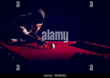 Un homme avec une barbe joue un grand billard. Banque D'Images