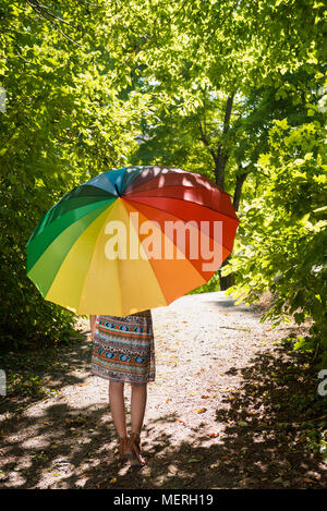 Portrait d'une belle jeune femme avec un parasol marche à travers la forêt de l'été vue de l'arrière Banque D'Images