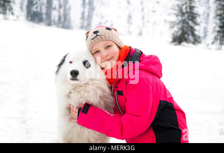 Happy girl hugging dog husky en plein air journée d'hiver. Banque D'Images