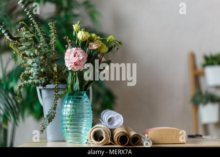 Image d'un fleuriste avec vase de fleurs à table Banque D'Images