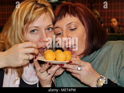 La Russie, Briansk, 20 mars 2012. Le concept de communication et d'amitié-souriante jeune femme avec un repas au café. Banque D'Images