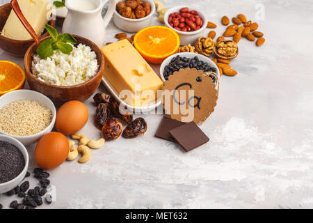 Suivre un régime alimentaire sain nutrition concept. Assortiment de sources riches en calcium. Produits laitiers, légumineuses, œufs, noix, chocolat, pavot, sésame, le chocolat. Banque D'Images