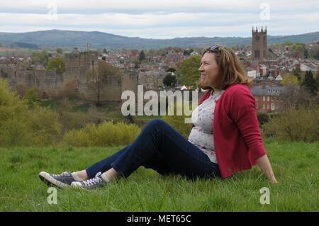 Une femme se détendre sur Whitcliffe commun avec Ludlow Castle dans l'arrière-plan. Banque D'Images
