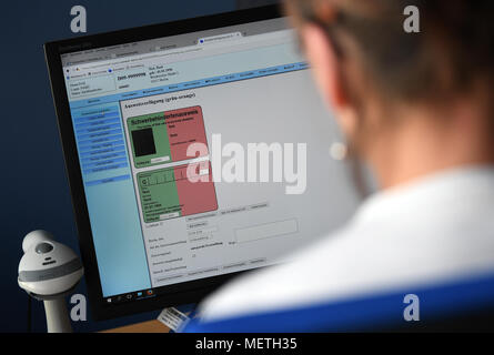 23 avril 2018, Allemagne, Berlin : Un employé de l'Office d'Etat de Berlin pour la santé et les affaires sociales démontre l'issueing d'une personne handicapée's pass. Photo : Britta Pedersen/dpa-Zentralbild/dpa Banque D'Images