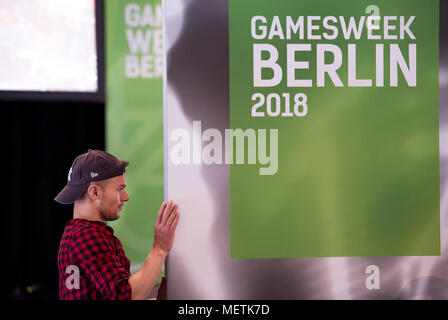 23 avril 2018, Allemagne, Berlin : un homme porte une bannière 'lecture Gamesweek Berlin 2018". L'ordinateur et aux jeux vidéo # 2018 gamesweekberlin équitable commence aujourd'hui à Saeaelchen à la gare Ostbahnhof. Photo : Lisa Ducret/dpa Banque D'Images