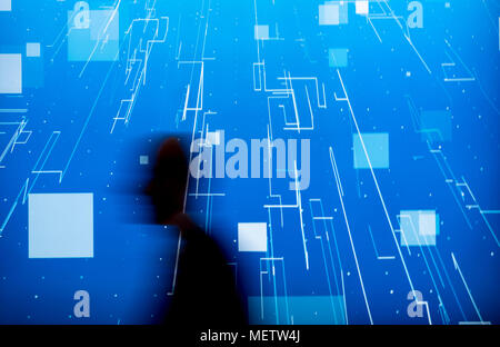 Hanovre, Allemagne. 23 avril 2018, un visiteur de la foire de Hanovre 2018 en passant par un écran. Photo : Peter Steffen/dpa dpa : Crédit photo alliance/Alamy Live News Banque D'Images