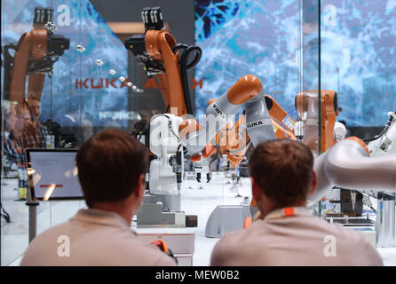 Hanovre, Allemagne. Apr 23, 2018. Les membres du personnel du stand de KUKA regarder la 'Smart' en usine au cours de la Foire de Hanovre 2018 à Hanovre, Allemagne, le 23 avril 2018. Salon de Hanovre, le premier salon, ouvert le dimanche, comme la chancelière allemande Angela Merkel a souligné l'importance du libre-échange. Credit : Shan Yuqi/Xinhua/Alamy Live News Banque D'Images