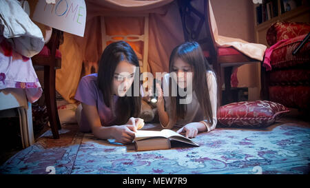 Portrait de deux adolescentes livre de lecture dans la chambre la nuit Banque D'Images