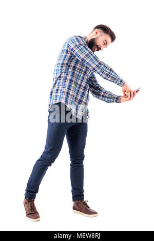 Jeune homme d'affaires furieux barbus poinçonnage téléphone mobile affichage avec le poing. Corps plein isolé sur fond blanc. Banque D'Images