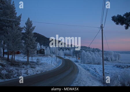 Le givre couvre un village à l'heure bleue sur une froide journée d'hiver. Bredbyn, Espagne, Suède. Bredbyn, Espagne, Suède Banque D'Images