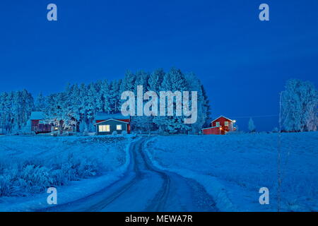 Le givre couvre un village à l'heure bleue sur une froide journée d'hiver. Bredbyn, Espagne, Suède. Banque D'Images