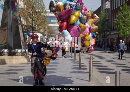 Vendeur de ballons sur High Street, Exeter Exeter avec la sculpture et l'Obélisque Riddle printemps coloré de parasols. Devon, Royaume-Uni. Avril, 2018. Banque D'Images