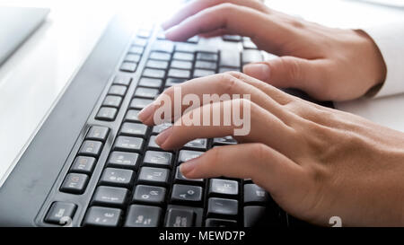 Photo de gros plan femme doigts sur clavier d'ordinateur au bureau Banque D'Images
