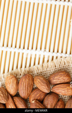 Amandes rôties sur un sac placé sur une table en bois, de copie, de l'espace fond d'amandes Banque D'Images