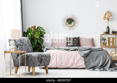 Photo brillant avec arrière-plan flou de chambre blanche avec des plantes d'intérieur, fauteuil et fenêtre avec des rideaux Banque D'Images