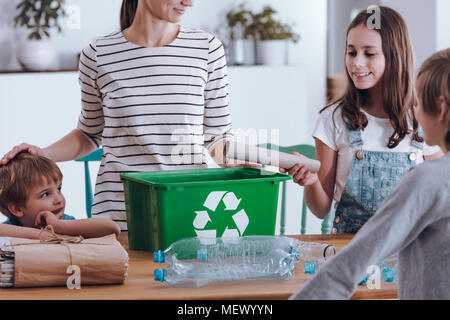 Conscient de l'enseignement de la mère smiling children comment recycler les déchets ménagers Banque D'Images