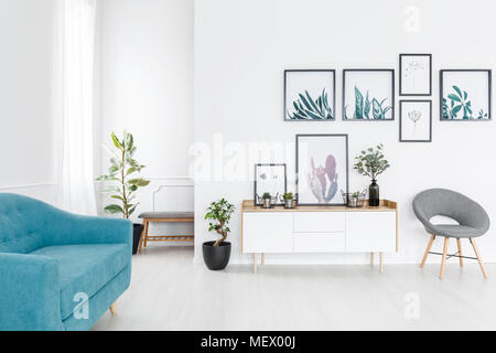 Galerie d'affiches simple pendaison sur mur blanc dans l'élégant salon intérieur avec canapé bleu Banque D'Images