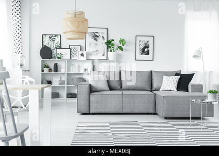 Studio intérieur blanc dans un style scandinave avec coin gris table, galerie d'art moderne et windows Banque D'Images