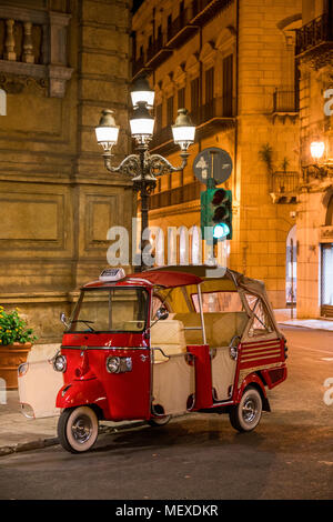 Quattro Canti Palerme en Sicile dans la nuit avec un taxi stationné à roues 3 rouge sur le coin. Banque D'Images