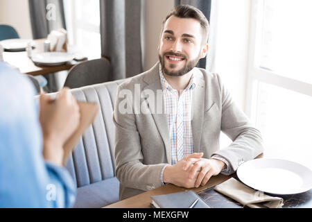 Cheerful businessman faire commander au restaurant Banque D'Images