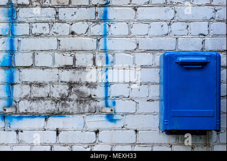 Boîte aux lettres bleu sur l'arrière-plan en brique blanche Banque D'Images