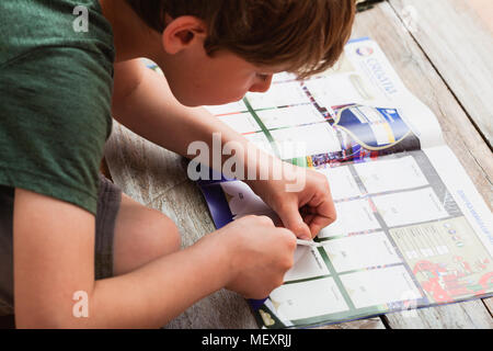 BERLIN, ALLEMAGNE - 20 avril 2018 : sept ans de coller des autocollants dans la collection Panini album pour le championnat du monde de football/soccer dans la R Banque D'Images