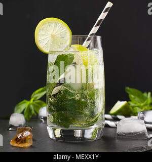 Mojito cocktail en verre avec garniture sur le tableau noir. Photo clé faible. Close up. Image carrée. Banque D'Images