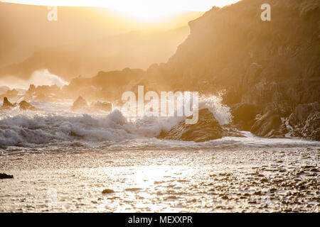 Golden sunset over rocky Pembrokeshire Coast, éclaboussures des vagues et brise du soir,falaises et brume en arrière-plan.paysage pittoresque Uk.côte britannique le coucher du soleil. Banque D'Images