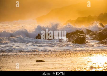 Golden sunset over rocky Pembrokeshire Coast, éclaboussures des vagues et brise du soir,falaises et brume en arrière-plan.paysage pittoresque Uk.côte britannique le coucher du soleil. Banque D'Images