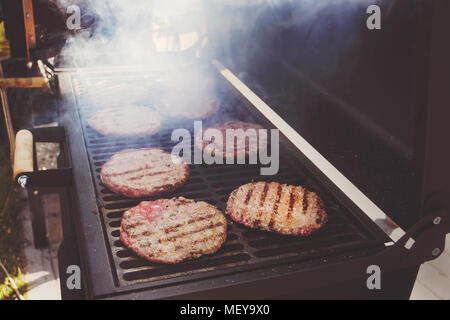 Macro closeup vue des frais généraux des galettes de viande hachée de boeuf recette brûlée par grill et cuisson sur lignes marques barbecue à charbon noir Banque D'Images