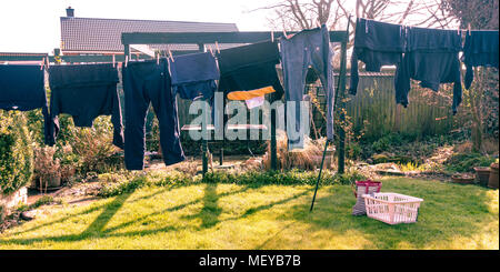 Vêtements en train de sécher dehors sur une ligne de lavage dans un jardin arrière. Banque D'Images