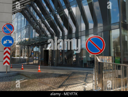 Close-up shot of no parking signalisation routière contre l'entrée de l'immeuble de bureaux modernes dans le verre Banque D'Images