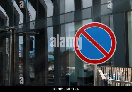 No parking signalisation routière contre l'entrée de l'immeuble de bureaux modernes dans le verre Banque D'Images