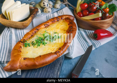 Khachapuri géorgien traditionnel est un pain au fromage. Du pain avec du fromage et des œufs avec les verts. Banque D'Images